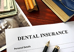Dental insurance paperwork on a desk with X-ray