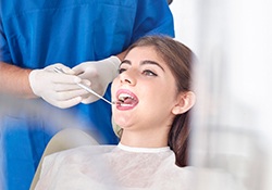 Lady getting teeth examined with dental mirror