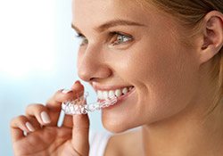 Harrisonburg Cosmetic Dentist Woman putting on clear aligners