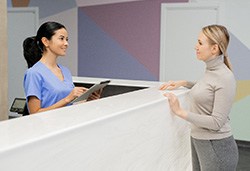 Patient and dental team member interacting at front desk