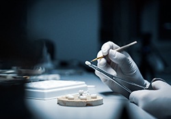 A lab worker making dental crowns