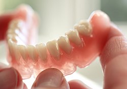 A denture soaking in a glass of water and denture cleaning solution