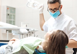 A dentist checking a female patient’s mouth