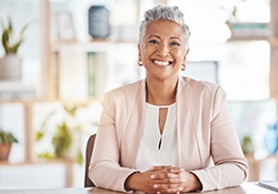 Senior woman sitting at a table and smiling