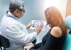 a dentist speaking with a patient about their X-ray 