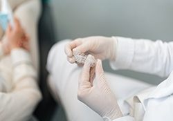 Dentist holding two Invisalign aligners