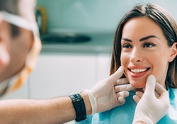 Dentist inspecting woman’s beautiful smile after Invisalign in Harrisonburg