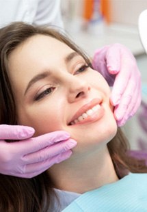 patient smiling in dental mirror 
            