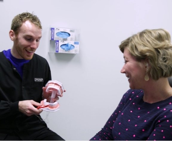 dentist showing patient teeth model
