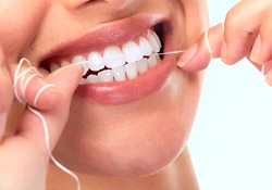 A woman flossing her teeth