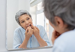 Woman smiling while flossing her teeth
