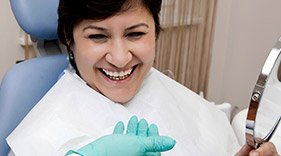 Pleased lady holding mirror smiling