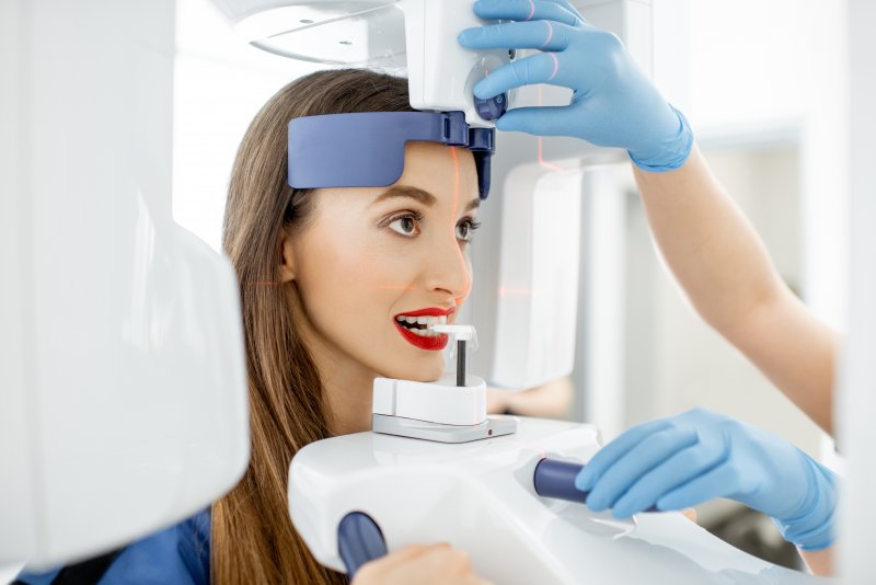 a young woman with her head situated in a Cone Beam Scanner