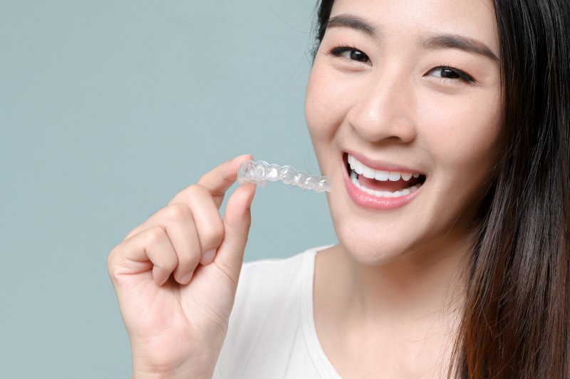 person putting on Invisalign aligner tray 