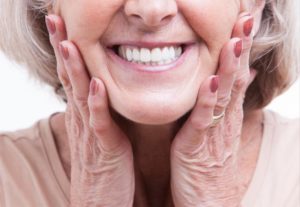 a woman happily showing off her smile with replaced dentures