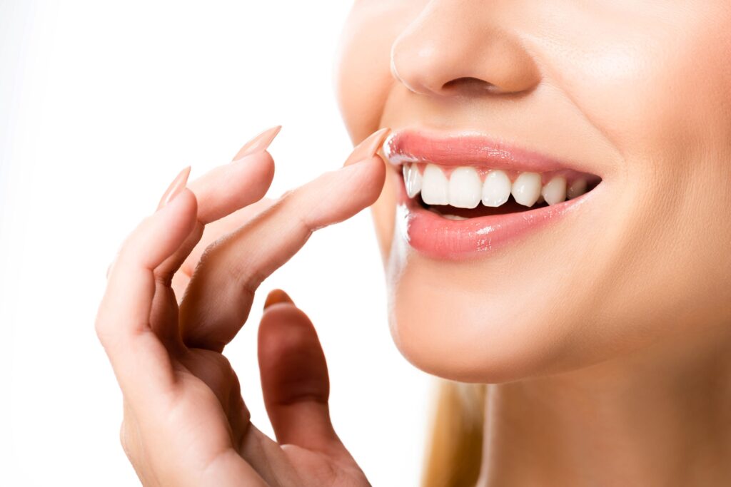 Nose-to-neck view of woman smiling and touching upper lip
