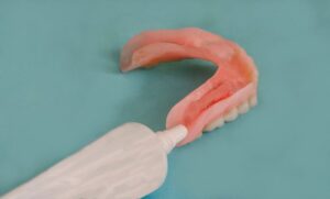 Person putting on denture adhesives